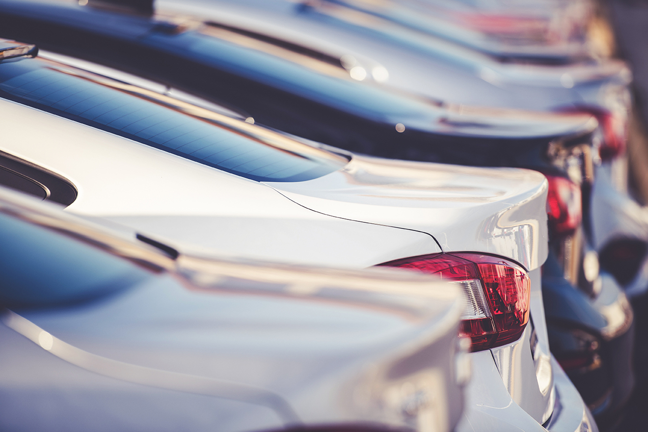 A line of parked new cars on a dealership lot